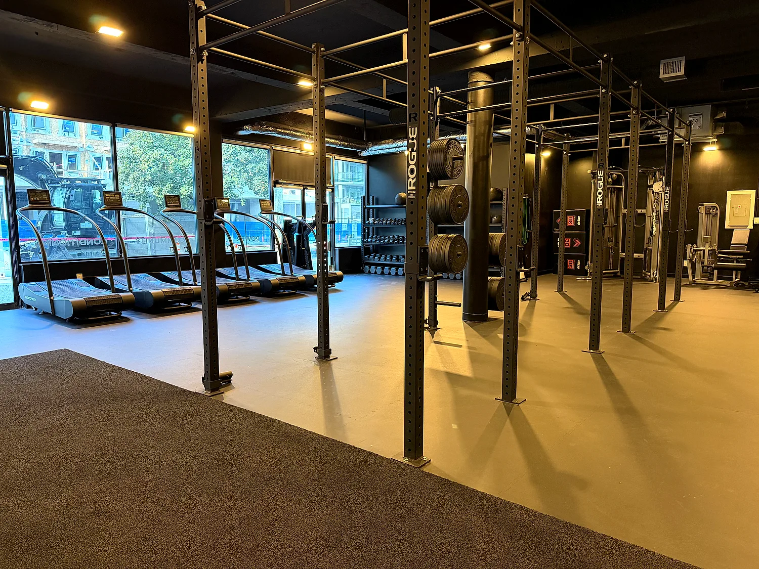 Training floor with squat rig, weight plates and treadmills at the Lower Lonsdale studio